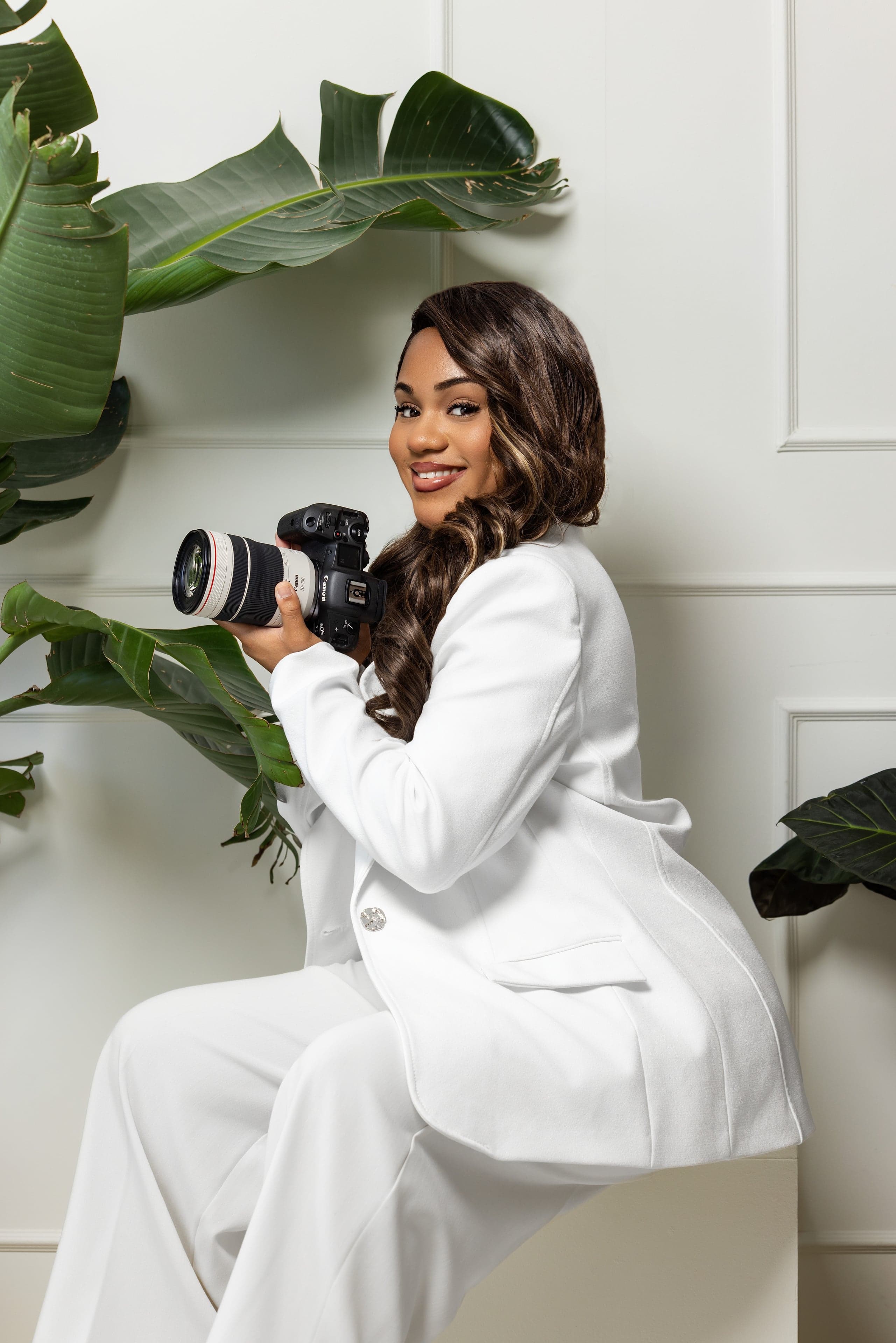 Emily holding her camera in her photography studio